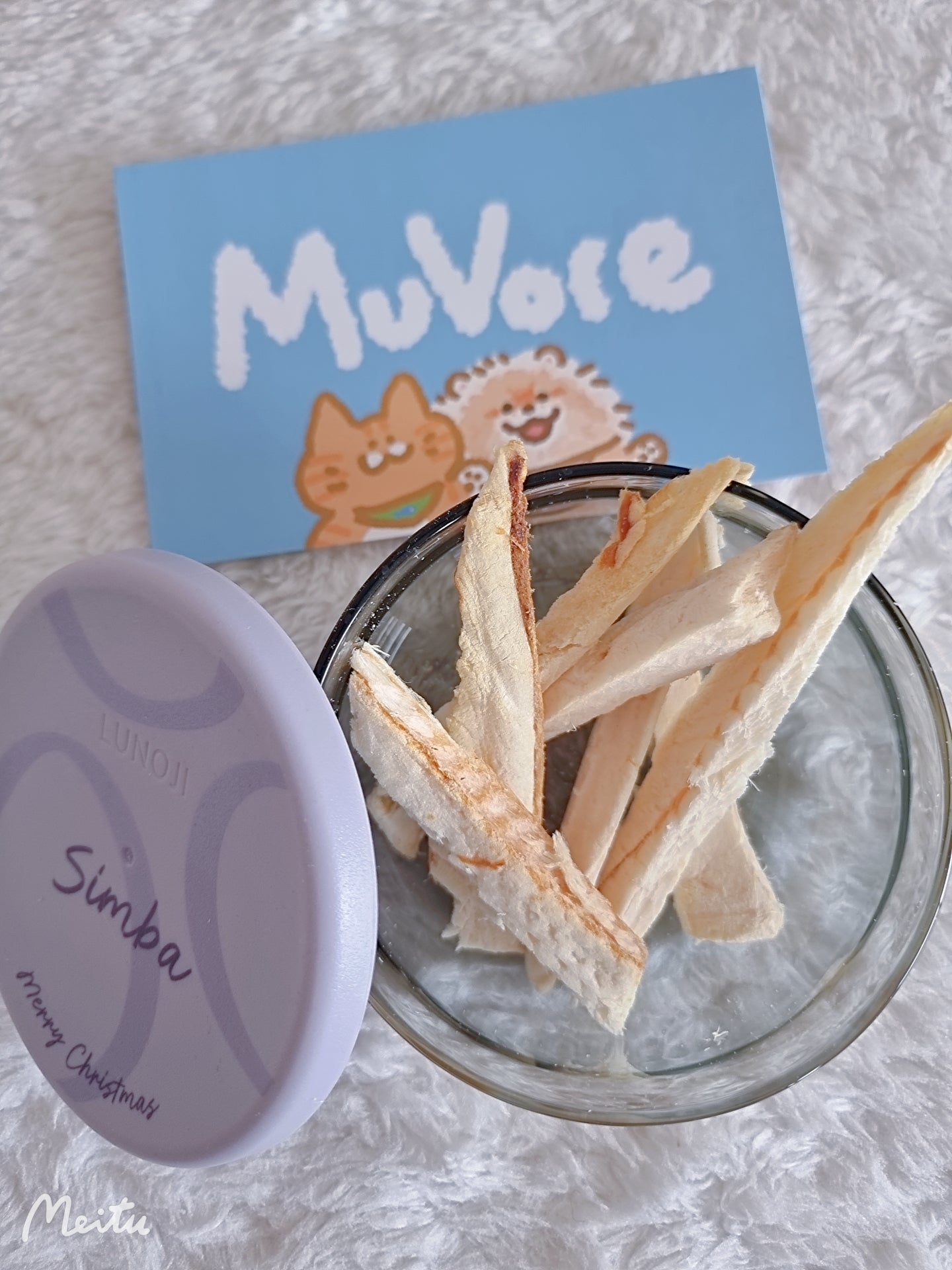 Glass container with freeze dried Hoki fillet, purple lid labeled 'Simba', and blue card with 'MuVore' branding on a textured surface.
