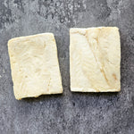 Two square pieces of Pollock fillets on a gray surface