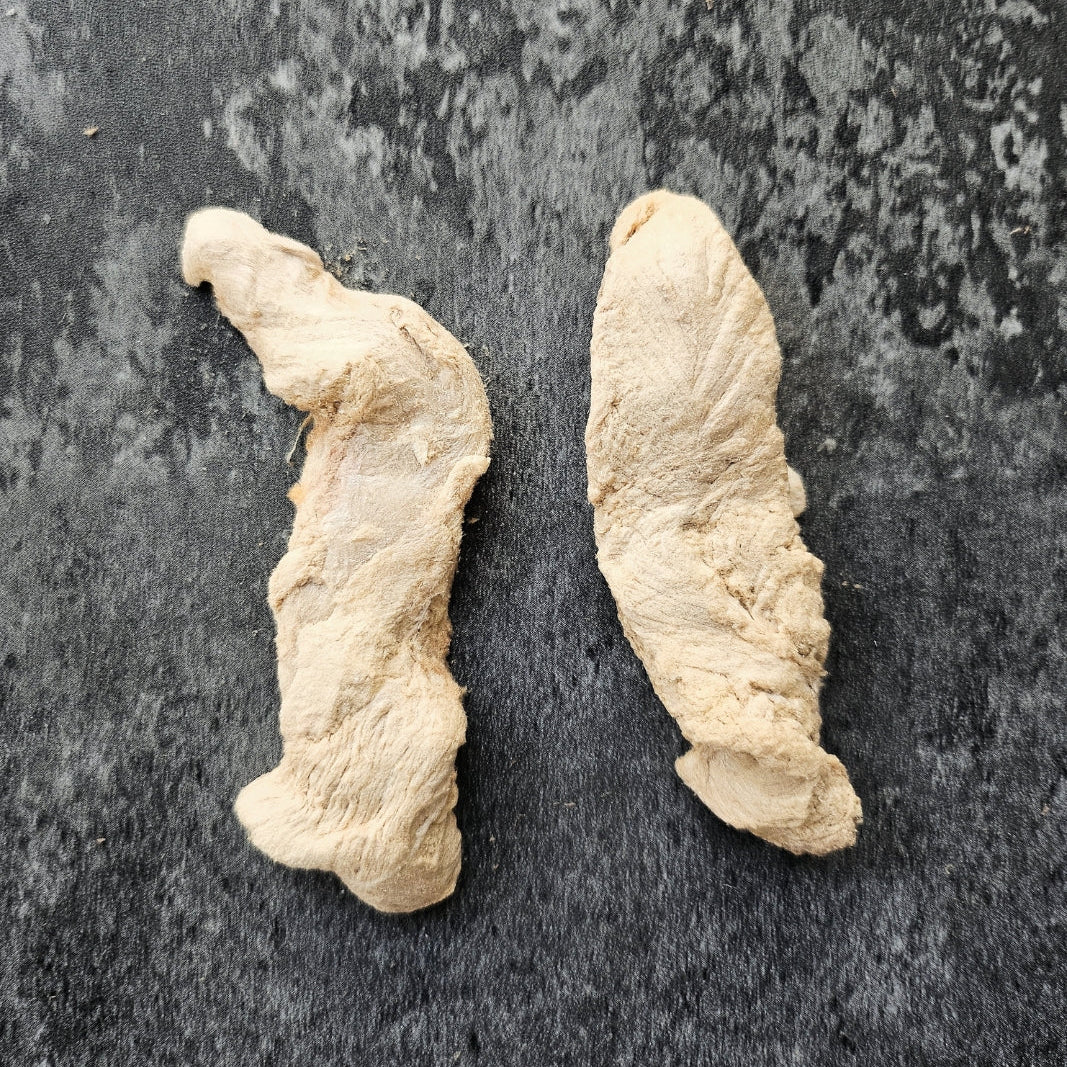 Two pieces of freeze dried duck Tenderloin on a dark surface