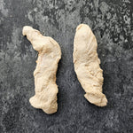 Two pieces of freeze dried duck Tenderloin on a dark surface